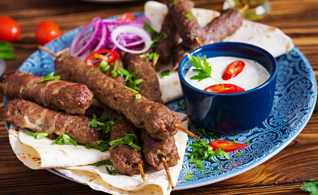 Turkish and Arabic Traditional Ramadan mix kebab plate. Kebab adana, chicken, lamb and beef on lavash bread with sauce. Top view